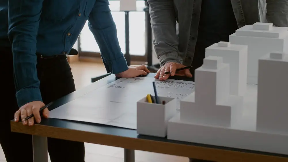 Architecten bespreken bouwplannen met maquette op kantoor